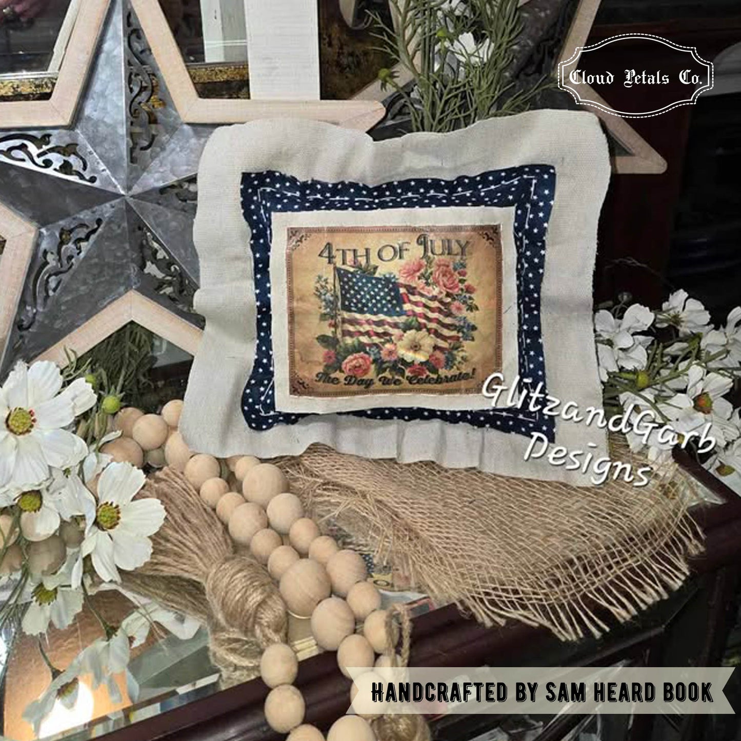 Decorative pillow with American flag design on a table with flowers and beads