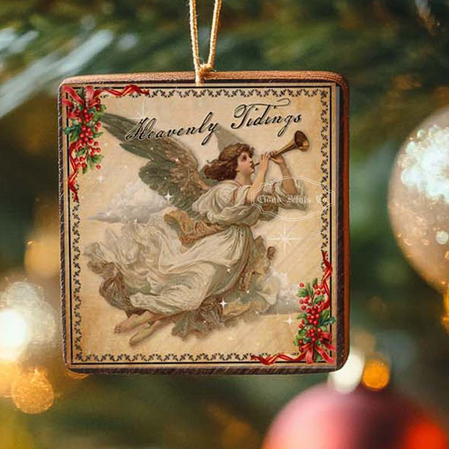 Vintage Christmas angel square ornament with 'Merry Christmas' text on a blurred Christmas tree background.