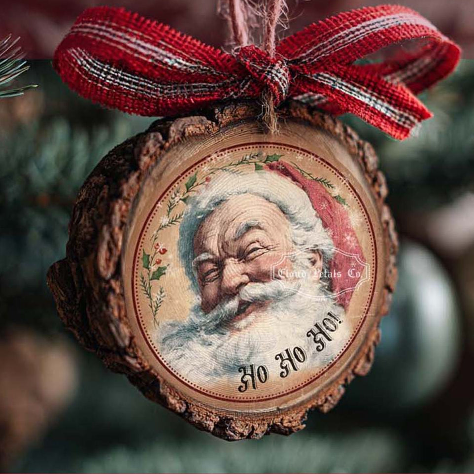 Round Christmas tag with Santa Claus design and red ribbon on a blurred Christmas tree background.